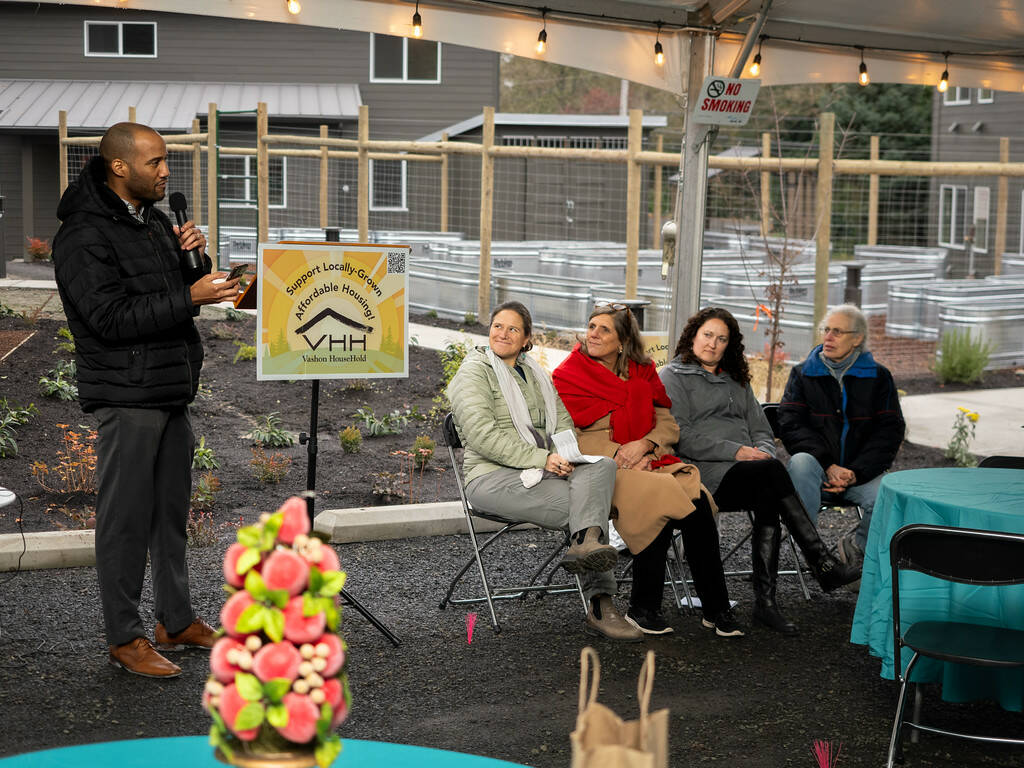 Chris Lovings, community engagement specialist at the Washington State Department of Commerce, speaks to the crowd at Island Center Homes. (John Decker photo)