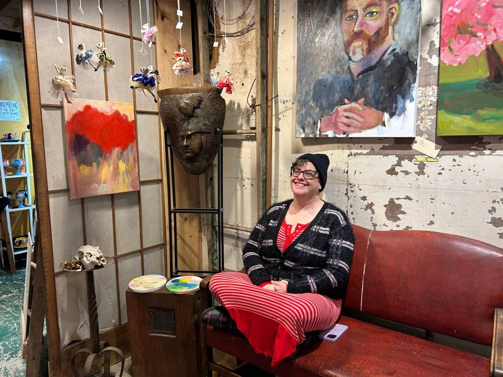 Rachel LordKenagas portrait of a stern man looks down on her smiling face during the studio tour. (Tom Hughes photo)