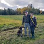 Morgan Brown, Pia Bloom and their dog Suki stand in front of the field on the south side of S.W. 178th. (Leslie Brown photo)