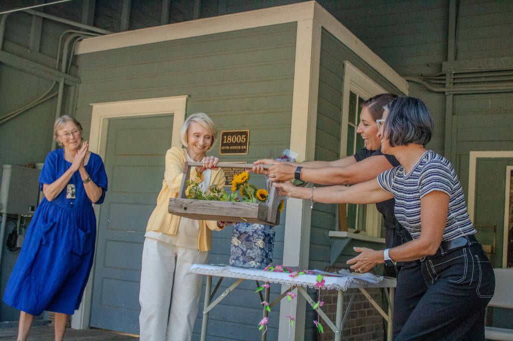 From left to right: Lynn Greiner, Kay Longhi, Teresa Mosqueda and Jennifer Meisner. In this photo, Mosqueda passes a basket to the Friends of Mukai representing the physical transfer of the barreling plant property back to the Vashon community. (Alex Bruell photo)