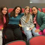 (Left to right) Alana Bass, Amelia Medeiros, Annabelle Moeckel, and school nurse and track coach Brandi Greenidge sit together after the school board meeting. In an emotional appeal, the three students urged the board not to cut Greenidges job. (Elizabeth Shepherd photo)