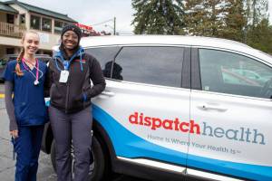 EMT Bailey Black and nurse practitioner Christian Graves stand next to their DispatchHealth van in Vashon. (Alex Bruell file photo)
