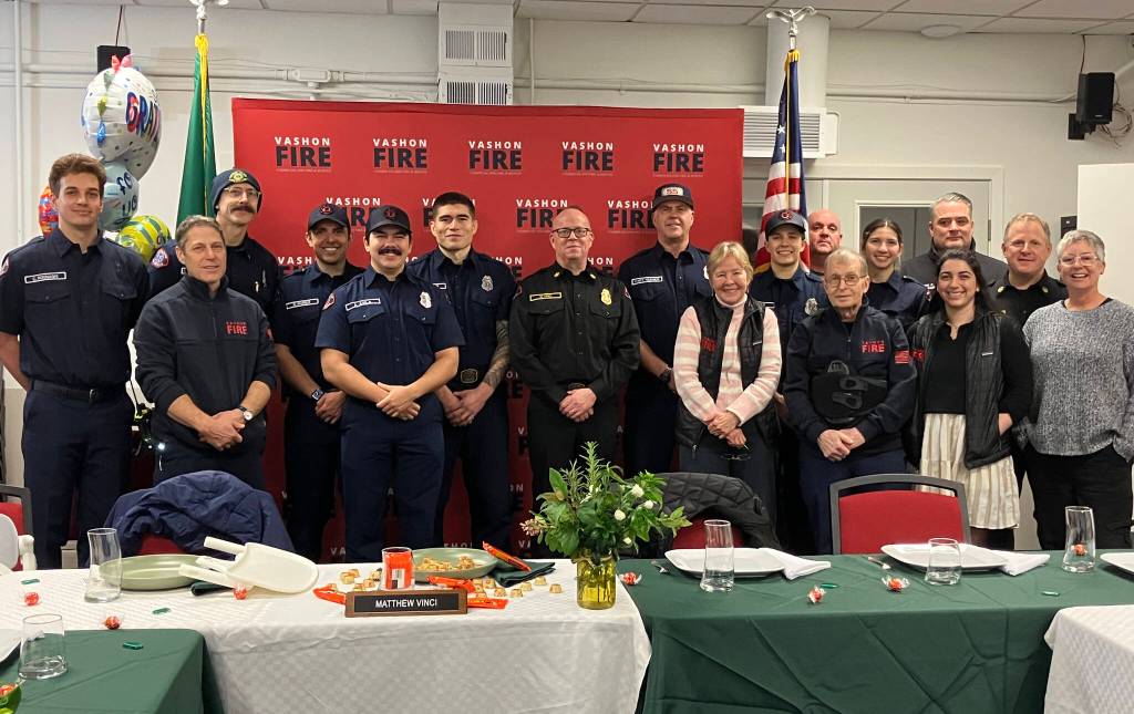 Staff of Vashon Island Fire Rescue surround Matt Vinci (center) on Friday, after a luncheon on his last day as Vashons fire chief. Deputy Chief Ben Davidson (second from right) now leads the district. (Elizabeth Shepherd photo)