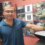 Jeremy Su stands next to the shea nut roaster that Burn Design Lab recently designed. On the shelves behind him are many other of the labs household stoves. (Courtesy photo)