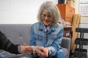 Alex Bruell photo
Grannys Attic volunteer Vicki Clabaugh smiles while holding the arm of Holly Beemer, who is wearing a bracelet of family names which she accidentally donated to the island thrift store while moving several months ago.