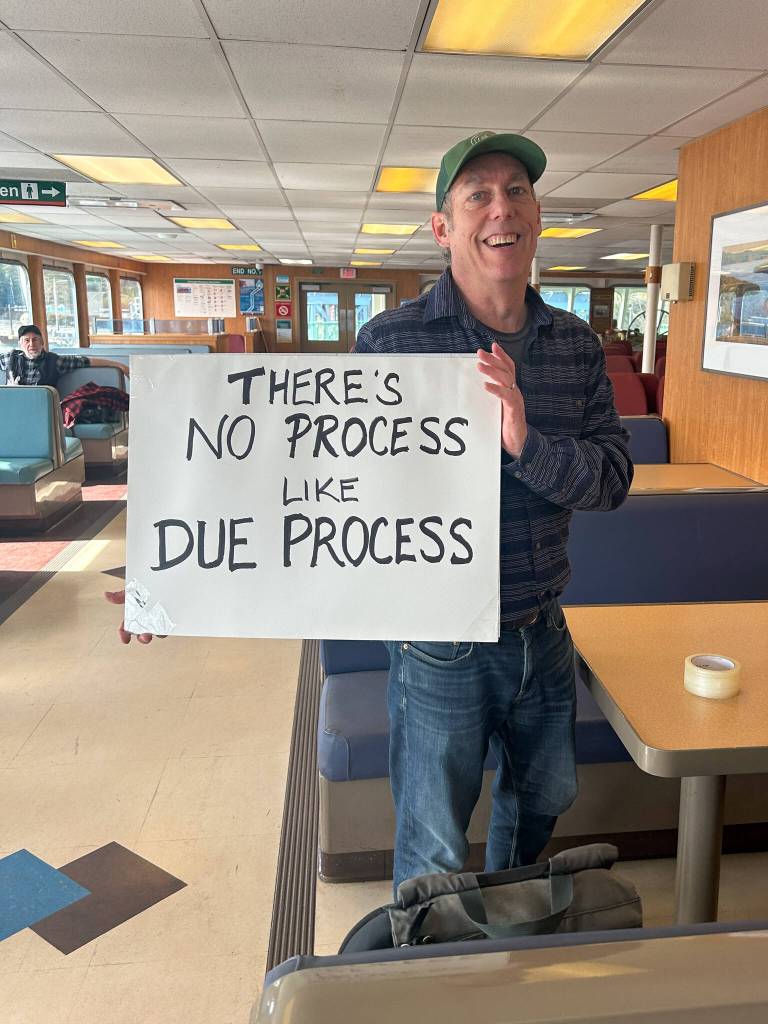 Christy Clement photo
Islander Seth Zuckerman displays a sign reading Theres No Process like Due Process on the ferry trip over to Seattle.