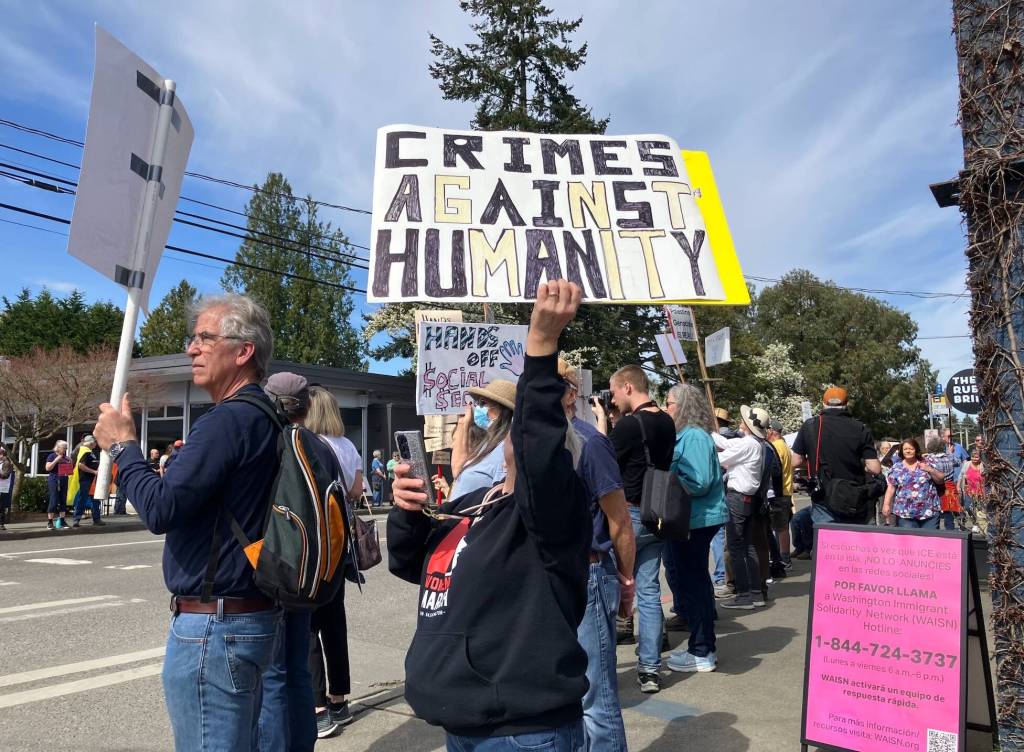 Elizabeth Shepherd Photo
Islanders lined the four-way interesection in the center of town on Saturday, with some standing by another sign of the times: an recently placed sandwich board advising Vashon residents what to do if they see immigration and customs enforcement officers on the island.