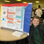 Sixth-grader Benjo D., with another student who was absent on the day of the science fair community presentation, explored the effects of using differing amounts of ingredients in smoke bombs. (Elizabeth Shepherd photo)