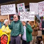 Demonstrators hold signs on Vashon April 19. (Kent Phelan photo)
