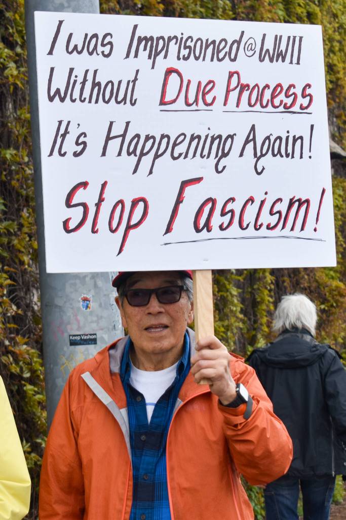 Islander Joe Okimoto holds a sign at the April 19 protest. (Alex Bruell photo)