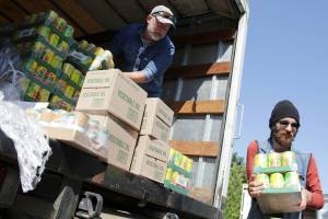 Vashon Food Bank co-manager Michael Whitmore and volunteer Eli unload food the morning of June 3. (Alex Bruell photo)