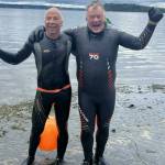 Joe Yarkin (left) and Theo Eicher celebrate the conclusion of their dock to dock swim at the north end ferry dock. (Pat Call photo)