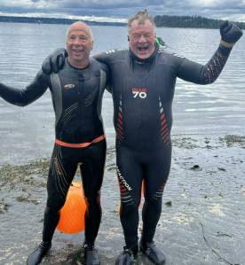 Joe Yarkin (left) and Theo Eicher celebrate the conclusion of their dock to dock swim at the north end ferry dock. (Pat Call photo)