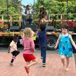 A pint-sized dancing crowd took to the stage during a performance of acclaimed islander Benjamin Hunter (onstage right) and his duo partner Joe Seamons at Snapdragon Bakery and Café. (Elizabeth Shepherd photo)