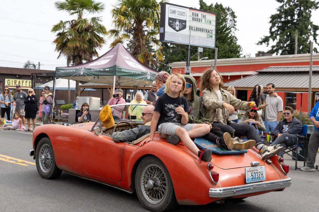 Kids crowd a car driven by Isaac Slade of Sidestack Records during the classic car parade. (Alex Bruell photo)