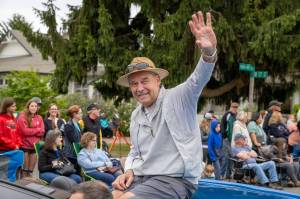 Festival parade Grand Marshal Doug Snyder waves to the crowd from a blue Corvette during the Strawberry Festival parade. (Alex Bruell photo)
