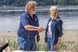 Camp Fire Executive Director Rick Taylor shakes hands with King County Executive Shannon Braddock at the easement signing ceremony July 10. (Alex Bruell photo)