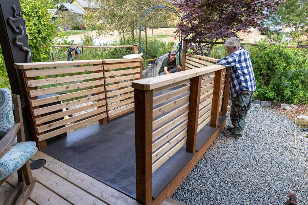 Fred Matusky admires the new ramp at his home as Meade Building Company workers finish applying paint. (Alex Bruell photo)