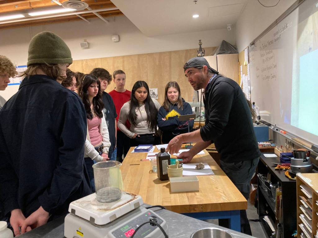 Vashon High School jewelry and chemistry students gather around Dr. Joshua Marceau as he discusses metallurgy. (Courtesy Photo)