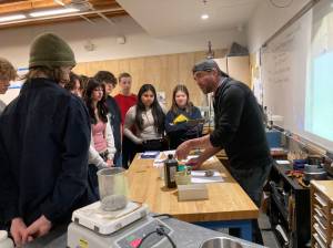 Vashon High School jewelry and chemistry students gather around Dr. Joshua Marceau as he discusses metallurgy. (Courtesy Photo)