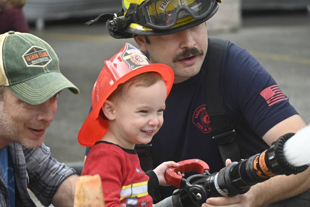 Kids, helped out by local firefighters, got a chance to take aim with powerful fire hoses at VIFRs open house. (Wade Yip Photo)