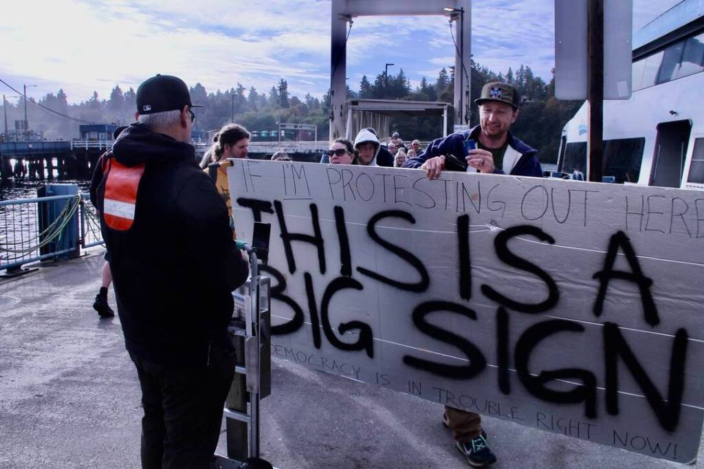Islanders brings big sign to protest. (Tom Hughes Photo)