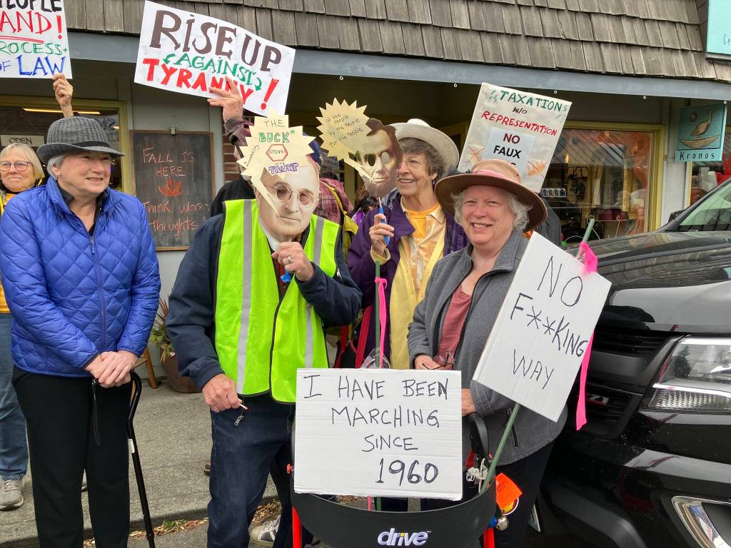 Islander Annie Robinson holds a sign reading, Ive been marching since 1960, during Saturdays protest in Vashons town center. (Elizabeth Shepherd Photo)