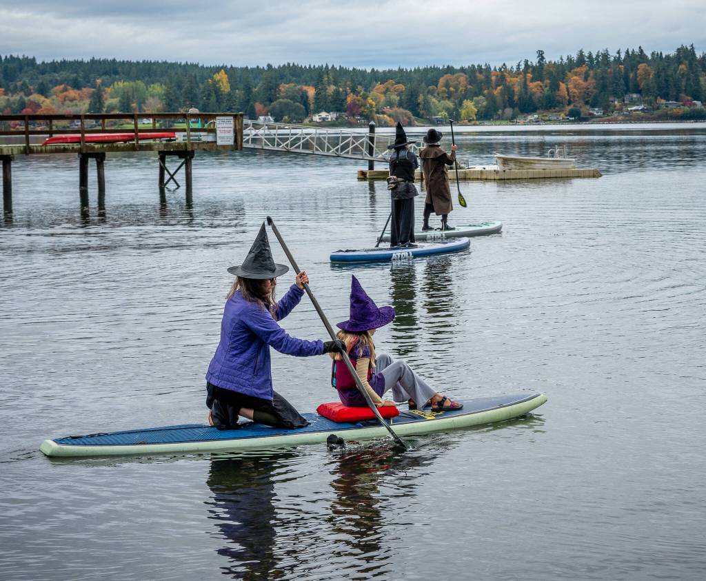 Participants paddle through gray skies and light rain at Jensen Point, keeping the islands witchy Halloween tradition afloat. (Kent Phelan Photo)