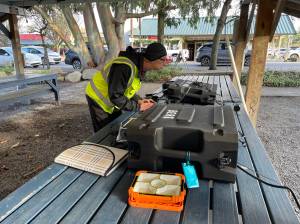 John Galus works at the Big Bird PCC to upload the latest channel listings onto a volunteers ham radio.