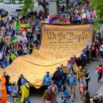 November: Protesters carry the We the People scroll through downtown Seattle during the No Kings protest on Oct. 18. (John Kunin Photo)