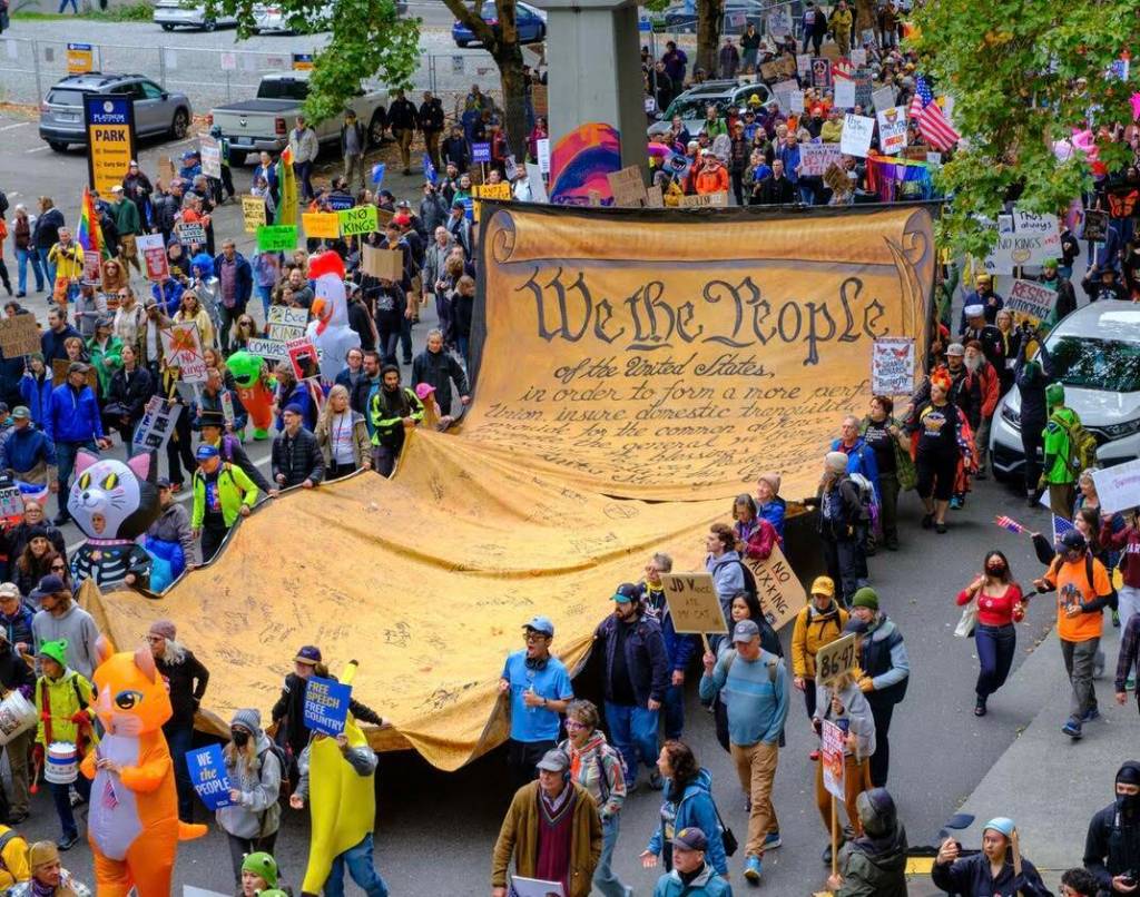 November: Protesters carry the We the People scroll through downtown Seattle during the No Kings protest on Oct. 18. (John Kunin Photo)