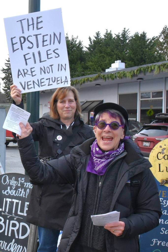 Janie Starr (foreground) of Vashon-Maury Showing Up for Racial Justice (SURJ) was one of the organizers of the impromptu protest. At the event, she passed out leaflets providing information how to contact legislators and get involved in the work of Indivisible Vashon. (Jim Diers Photo)