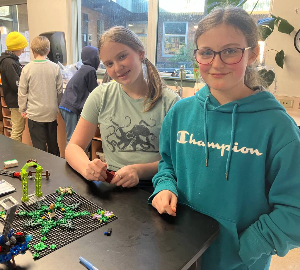 (Left to right) Middle-schooler Edie, and Mirabai, a fifth-grader, displayed their Lego project that Edie created based on a spooky story based in a woodland setting. (Elizabeth Shepherd Photo)