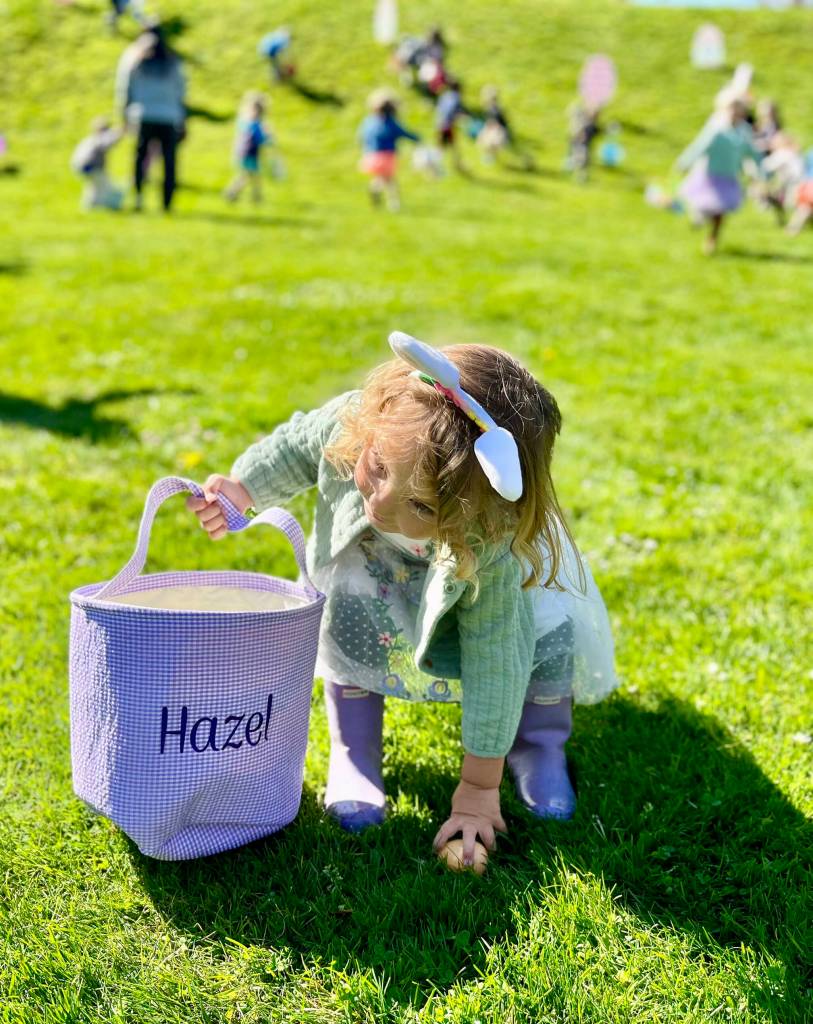 Two-year-old Hazel scoops up an egg at Ober Park on April 4 during the annual Eggstravaganza. Hazel and her family were visiting from San Diego, scouting a possible move to Vashon, when they stumbled onto the event.