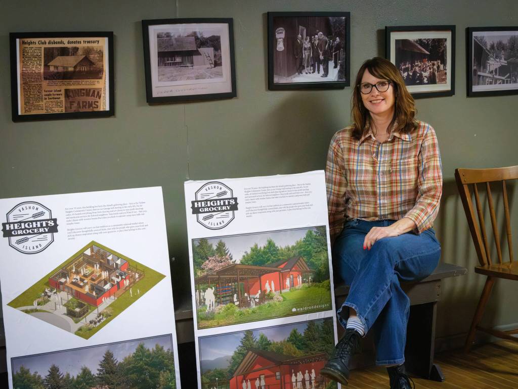 Terry Donnelly Photo
Jennifer Potter inside the future Heights Grocery with a rendering of the store.