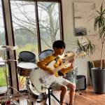 Karina Simons Photo
Elijah plays an electric guitar in of a drum set at his Vashon Island home. Both instruments were from the music instrument library, where hes also borrowed a keyboard and a cajon for free from the local non-profit.