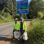 Courtesy Photo
Elizabeth Boutin (left) and Deborah Diamond stand in front of their Adopt-a-Road sign along Westside Highway. The retired IRS employees take time almost each day collecting litter along island roads, joking that theyve gone from tax collectors to trash collectors.