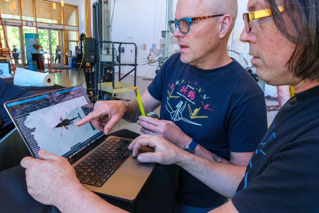 Terry Donnelly Photo
Volunteer Kevin Flick, left, and artist Ela Lamblin consult a digital model of Singer while assembling the whale skeleton at Vashon Center for the Arts. The model was built from 3D scans of the bones, which helped guide the installation.