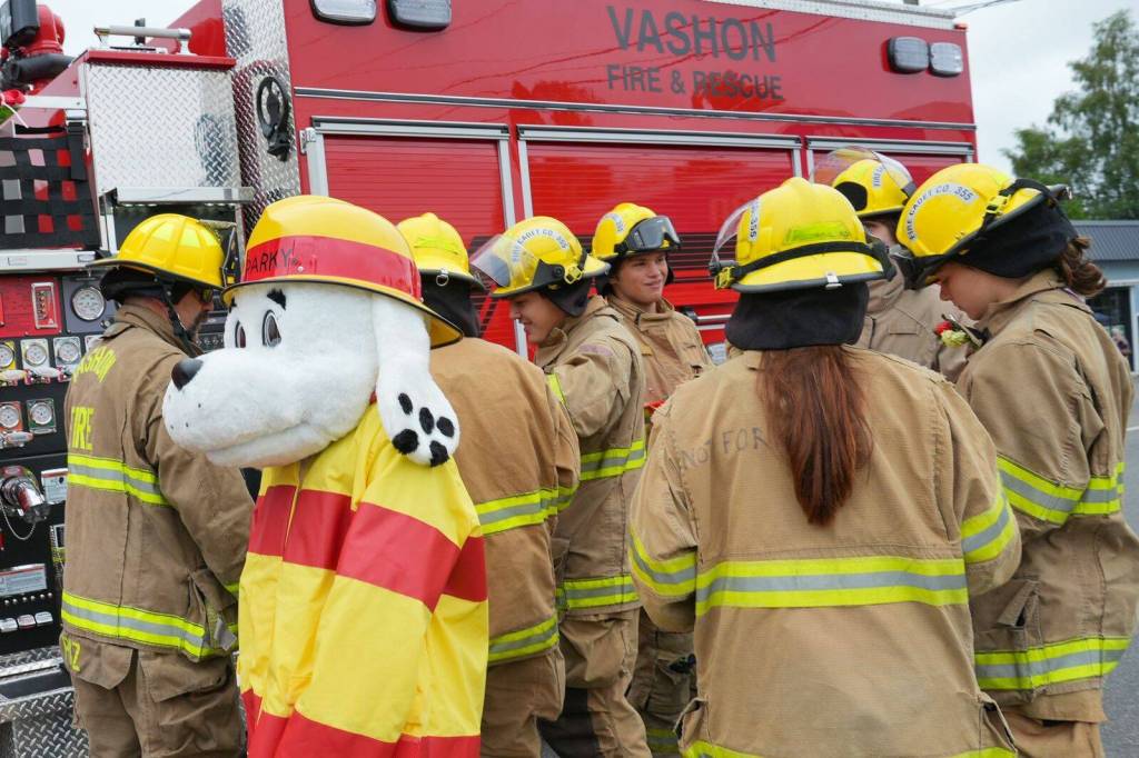 Jonathan Stein Photo
Vashon Island Fire & Rescue firefighters gather with Sparky the Fire Dog beside a fire engine during the Strawberry Festival Parade on Saturday.