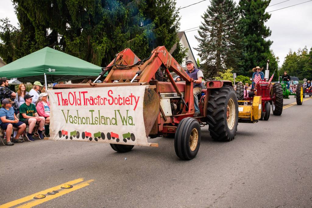 Kent Phelan Photo
Members of the Old Tractor Society rumble through uptown in a procession of vintage tractors.
