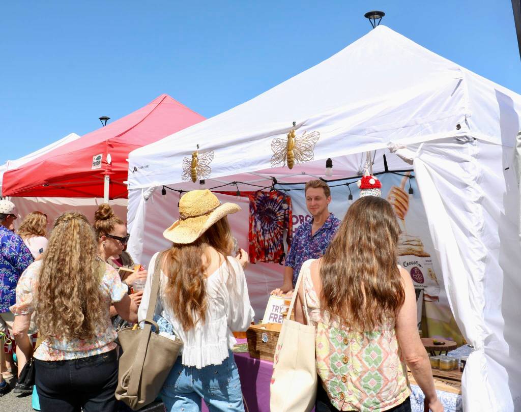 Scarlet Hansen Photo
Visitors sample local honey at a vendor booth.