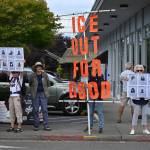 A handful of islanders stand beneath an ICE Out for Good banner during an anti-ICE vigil Saturday, July 25, near Vashons four-way stop. The demonstration was organized by Vashon-Maury Showing Up for Racial Justice. (Kent Phelan Photo)