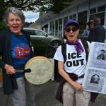 Demonstrators carry memorial posters and beat a drum during Saturdays anti-ICE vigil in uptown Vashon. (Kent Phelan Photo)
