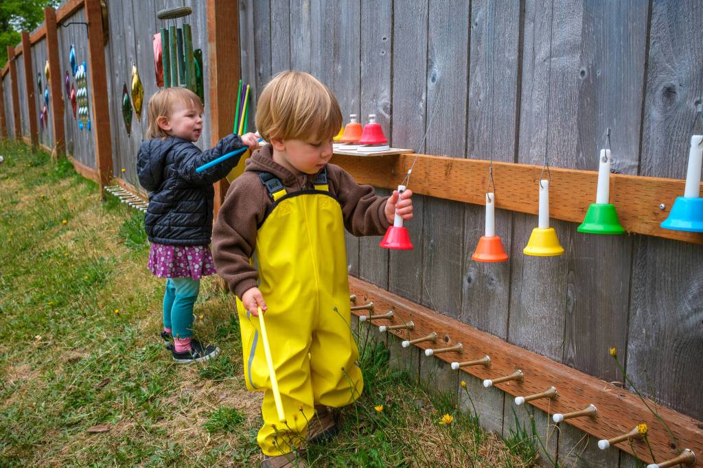 Calla and Elwyn play at the colorful music wall on the co-op playground. (Kent Phelan Photo)