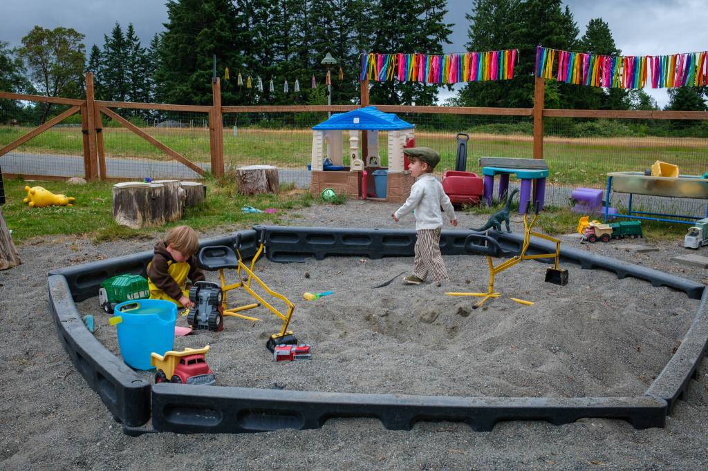 Elwyn and Ivo explore the sandbox on one of the co-ops two playgrounds. (Kent Phelan Photo)